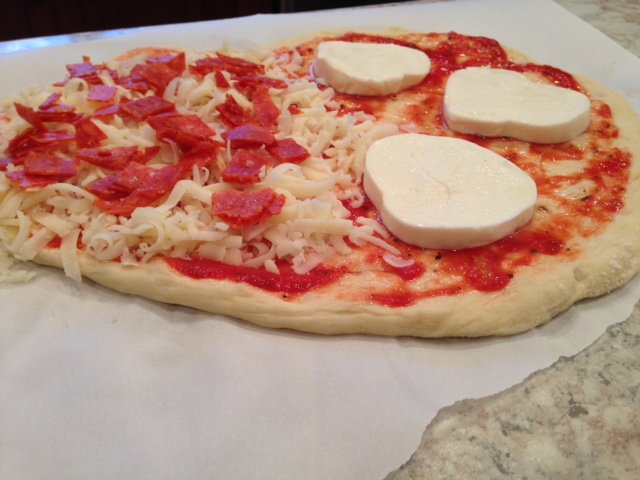 uncooked pizza on parchment